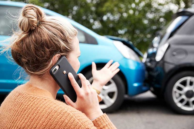Female-Motorist-Involved-In-Car-Accident-Calling-Insurance-Company-Or-Recovery-Service